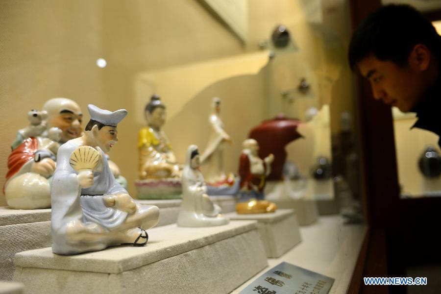 A visitor views the traditional Huating painting ceramics crafts during an exhibition in Huating County, northwest China's Gansu Province, Nov. 29, 2012.