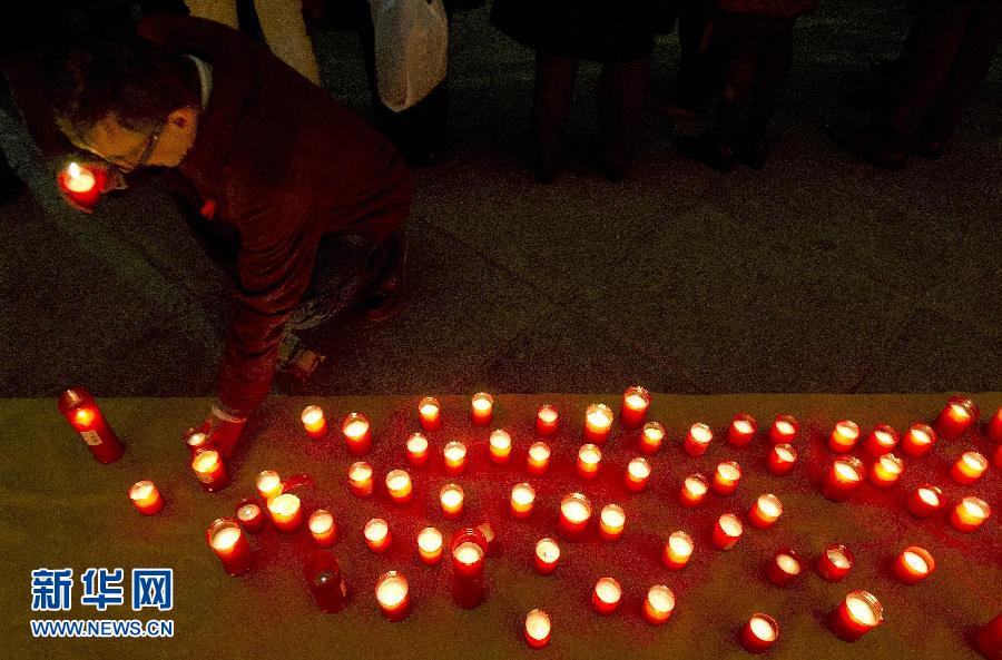 A man lights candles in an activity for the World AIDS Day in Madrid, Spain on Nov. 30, 2011. (Xinhua/AFP)