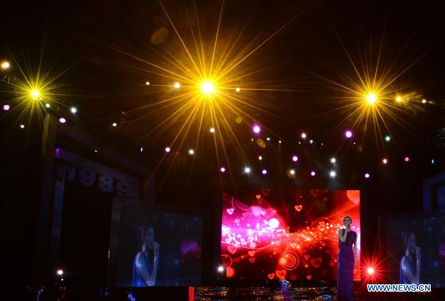 Model Gu Yu sings on the catwalks of a model competition in Sanya, south China's Hainan Province, Nov. 30, 2012. The final of the 20th New Silk Road Model Competition was held here on Friday. (Xinhua/Jin Liangkuai)