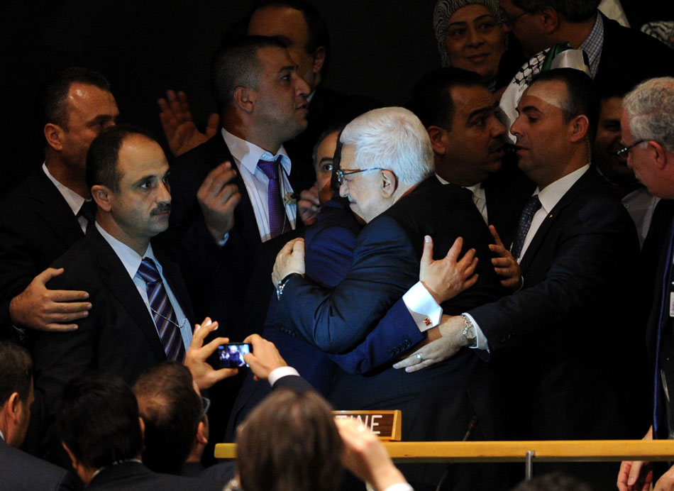 Palestinian President Mahmoud Abbas (C) gets a hug from Turkey's Foreign Minister Ahmet Davutoglu at the UN General Assembly (UNGA) meeting at the UN headquarters in New York, the United States, on Nov. 29, 2012. The UNGA on Thursday voted overwhelmingly to grant an upgrade of the Palestinians status at the United Nations from "entity" to "non-member state". (Xinhua/Shen Hong)