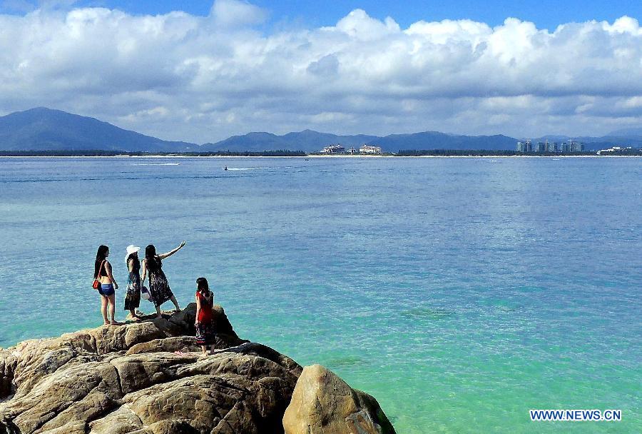 Several women enjoy the scenery by the seaside of Sanya, a famous tourism city in south China's Hainan Province, Dec. 1, 2012. As Sanya has entered its tourist season, more tourists are seen here. (Xinhua/Wang Song)