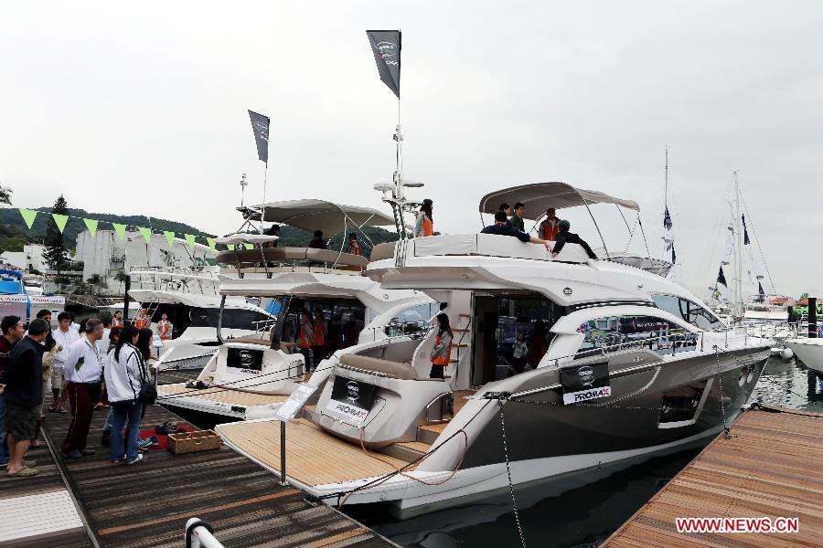 Visitors watch yachts on display at Hong Kong International Boat Show 2012 in south China's Hong Kong, Dec. 2, 2012. The boat show closed on Sunday. (Xinhua/Li Peng) 