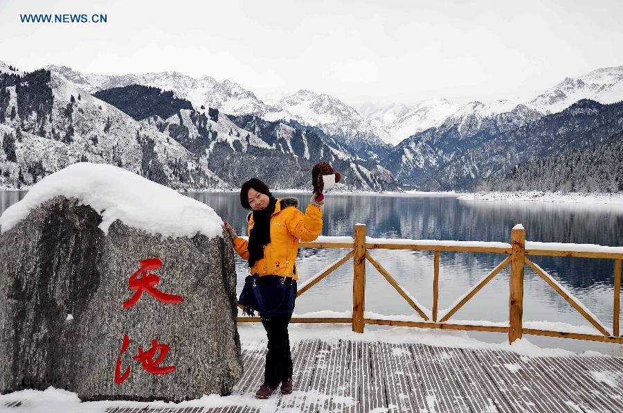 A tourist poses for a photo at the Tianchi Scenic Zone in the Tianshan Mountains, northwest China's Xinjiang Uygur Autonomous Region, Dec. 1, 2012. The Tianchi Ice and Snow Festival kicked off at the scenic spot on Saturday. (Xinhua/Yu Tao)