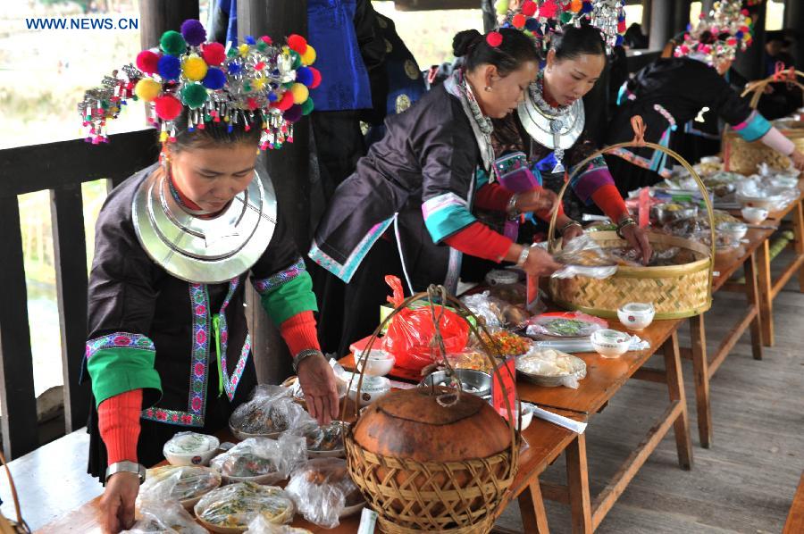 Women of the Dong ethnic group prepare a feast on the Chengyang Fengyu Bridge during a celebration ceremony marking the 100th anniversary of the completion of Chengyang Fengshui Bridge held in Sanjiang Dong Autonomous County, south China's Guangxi Zhuang Autonomous Region, Dec. 1, 2012. (Xinhua/Lai Liusheng)
