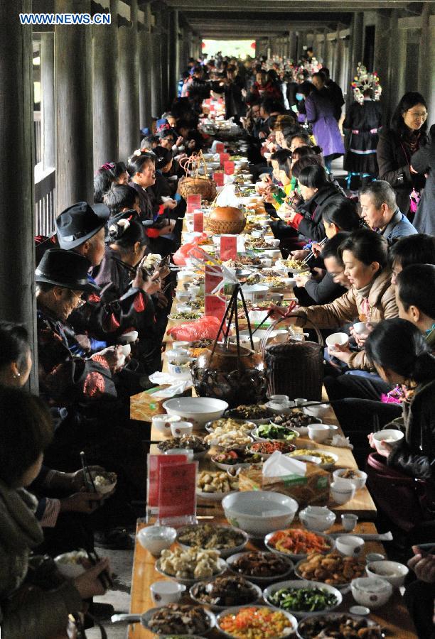 People of the Dong ethnic group attend a feast during a celebration ceremony marking the 100th anniversary of the completion of Chengyang Fengshui Bridge held in Sanjiang Dong Autonomous County, south China's Guangxi Zhuang Autonomous Region, Dec. 1, 2012.(Xinhua/Lai Liusheng) 