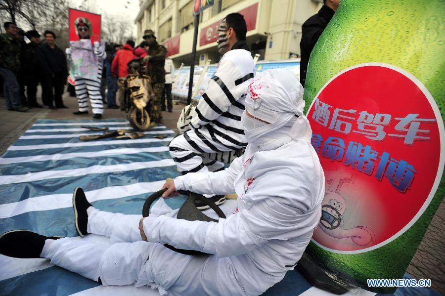 Volunteers perform to introduce the danger of drunk driving during an event to mark the country's first national day for road safety in Jinan, capital of east China's Shandong Province, Dec. 2, 2012. (Xinhua/Cui Jian)