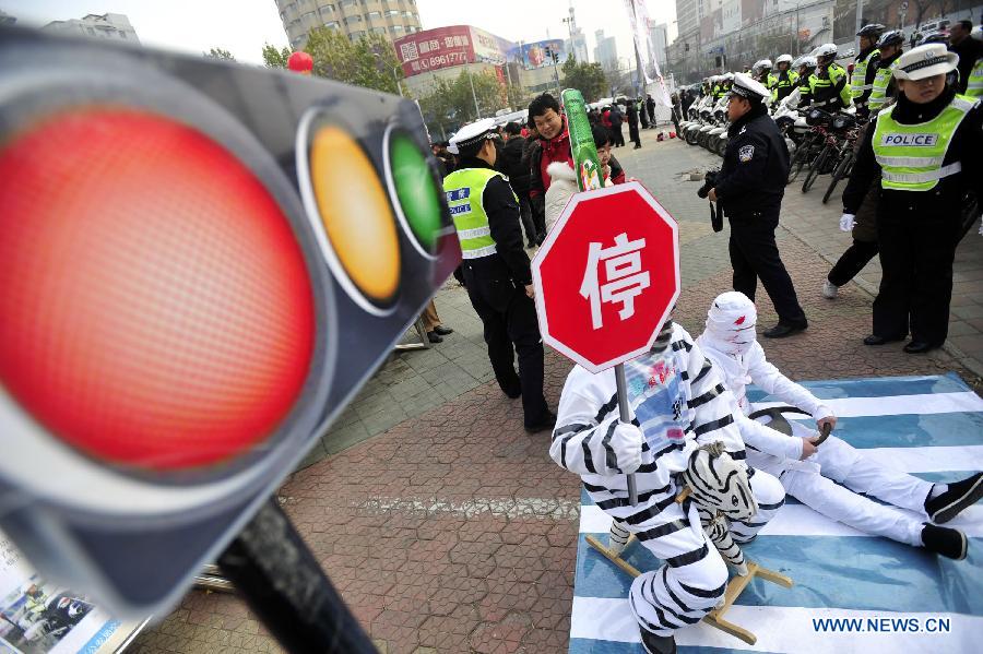 Volunteers perform to introduce the danger of drunk driving during an event to mark the country's first national day for road safety in Jinan, capital of east China's Shandong Province, Dec. 2, 2012. (Xinhua/Cui Jian)