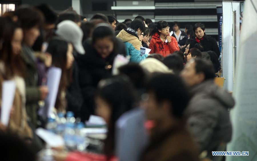 Students communicate with recruiters at a job fair in Tianjin Normal University in north China's Tianjin Municipality, Dec. 2, 2012. Tianjin Normal University held a job fair for its fresh graduates in 2013 on Sunday, which attracted over 200 enterprises. (Xinhua/Liu Dongyue)