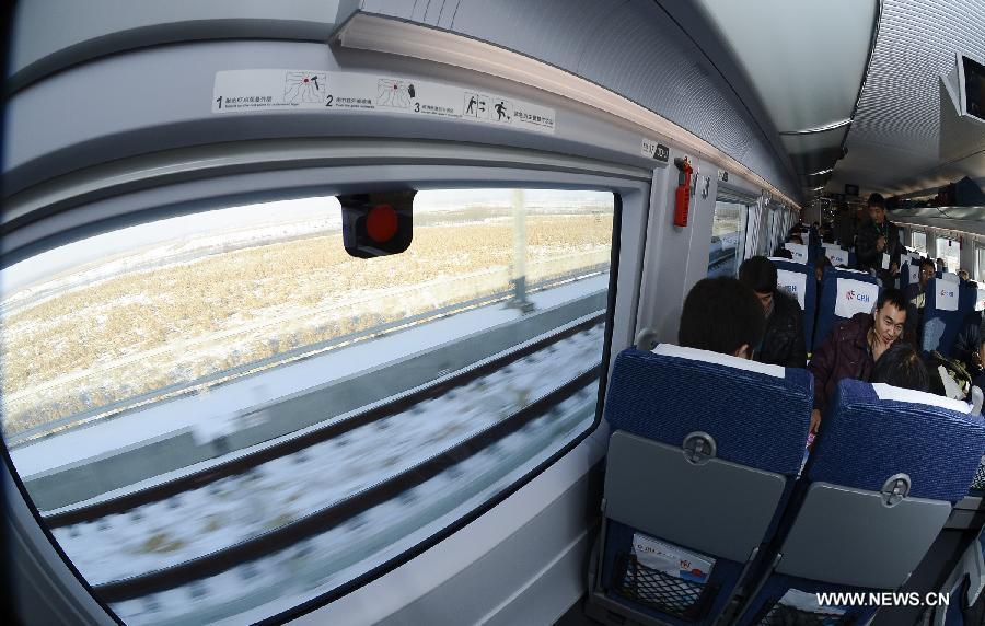 Passengers sit on a high-speed train from Harbin, capital of northeast China's Heilongjiang Province, Dec. 1, 2012. The world's first high-speed railway in areas with extremely low temperature, which runs through three provinces in northeastern China, started operation on Saturday. The railway links Harbin, capital of Heilongjiang Province, and Dalian, a port city in Liaoning Province. (Xinhua/Qi Heng)