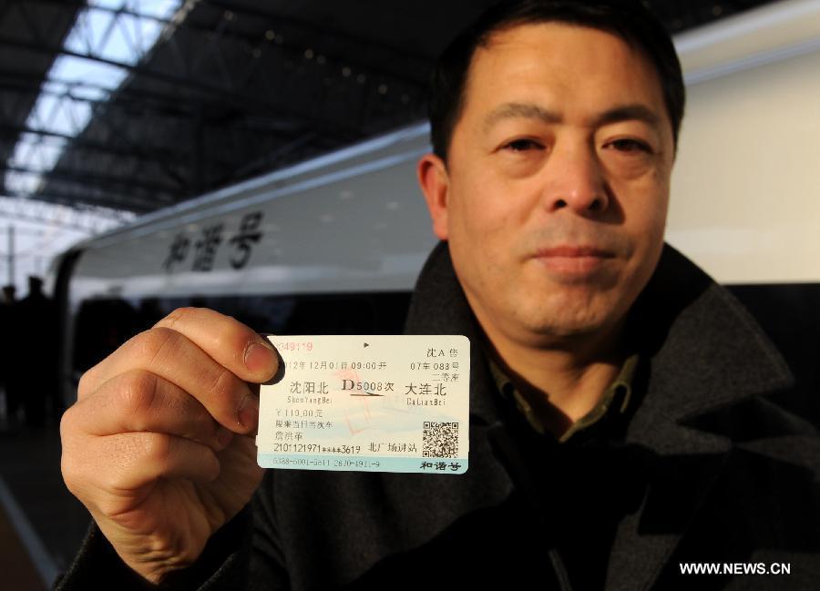 A passenger shows his ticket before boarding a high-speed train at the Shenyang North Railway Station in Shenyang, capital of northeast China's Liaoning Province, Dec. 1, 2012. The world's first high-speed railway in areas with extremely low temperatures, namely the Hada High-speed Railway which runs through the three provinces in northeast China, started operation on Saturday. The railway links Harbin, capital of Heilongjiang Province, and Dalian, a port city in Liaoning Province. (Xinhua/Li Gang) 