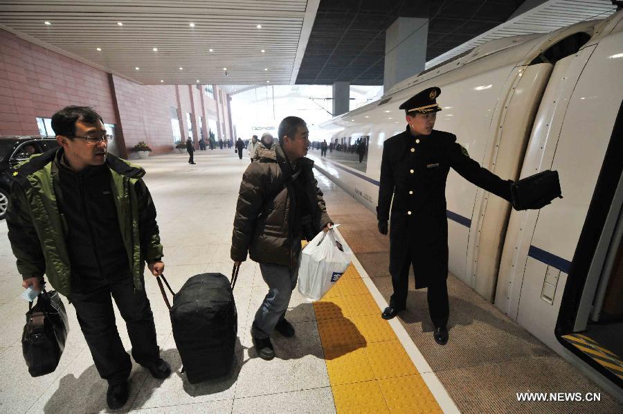 Passengers board a high-speed train at the Harbin West Railway Station in Harbin, capital of northeast China's Heilongjiang Province, Dec. 1, 2012. The world's first high-speed railway in areas with extremely low temperature, which runs through three provinces in northeastern China, started operation on Saturday. The railway links Harbin, capital of Heilongjiang Province, and Dalian, a port city in Liaoning Province. (Xinhua/Wang Jianwei)