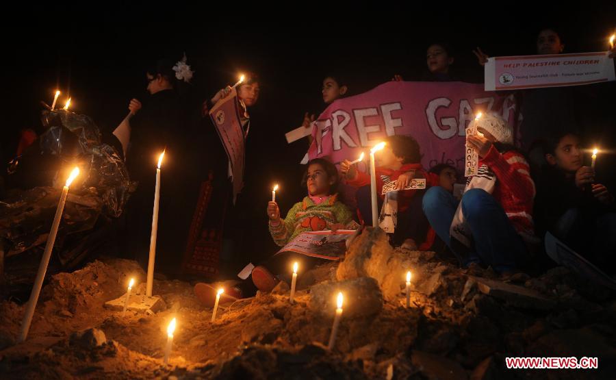 Palestinians children and international activists light candles around the destroying house of Al-Dalou family in Gaza City on Dec. 1, 2012. An Israeli bomb fell upon Al-Dalou family's two-storey house in Gaza City's residential al-Nasser neighborhood on Nov.18, killing 11, including four children and a woman as old as 81. It was one of the deadliest events in the latest conflict between Israel and Gaza militants. (Xinhua/Yasser Qudih)