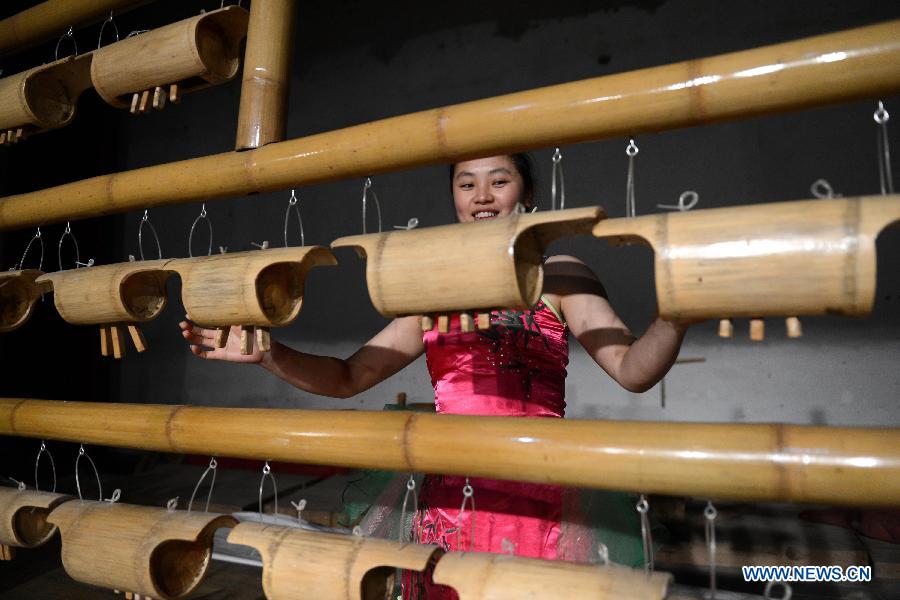 An actresses of an eco-bamboo band plays a bamboo instrument in Chongyi County, east China's Jiangxi Province, Dec. 1, 2012. (Xinhua/Zhou Ke)