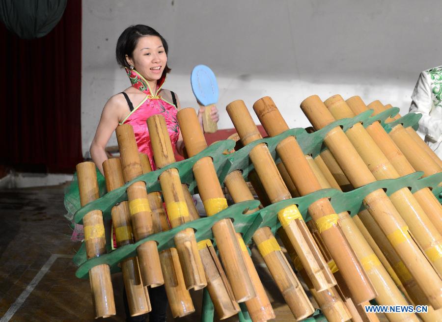 An actresses of an eco-bamboo band plays a bamboo instrument in Chongyi County, east China's Jiangxi Province, Dec. 1, 2012. (Xinhua/Zhou Ke) 