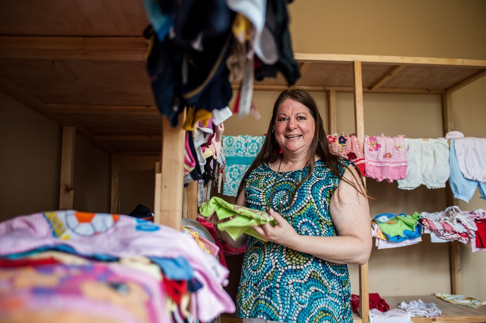 Pam Baker, wife of Tim Baker, collects donated children clothes at the Shepherd's Field in Tianjin, north China, May 29, 2012.(Xinhua/Zhang Chaoqun)