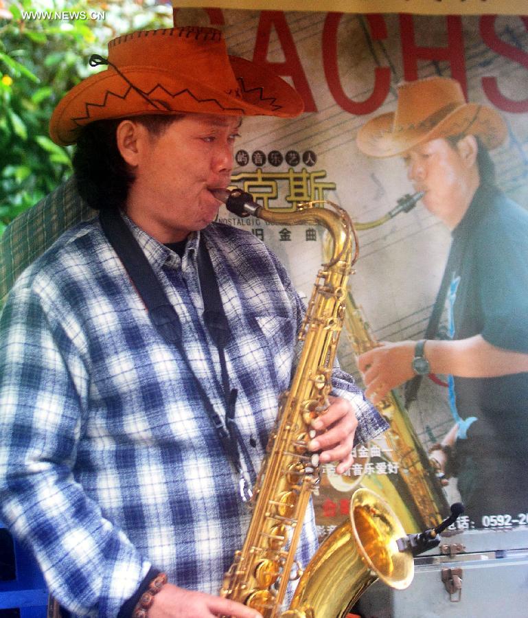 A street saxophonist gives performance on Gulangyu Island, a tourist resort in Xiamen, southeast China's Fujian Province, Dec. 1, 2012. (Xinhua/Zhang Weiguo)