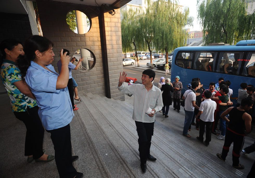 Salman Raha (C) bids farewell to a dormitory administrator at Taiyuan University of Technology in Taiyuan, capital of north China's Shanxi Province, July 11, 2012. 