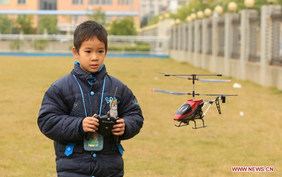 A young participant takes part in a model aircraft competition for teenagers in Rong'an County, southwest China's Guangxi Zhuang Autonomous Region, Dec. 2, 2012. (Xinhua/Tan Kaixing) 