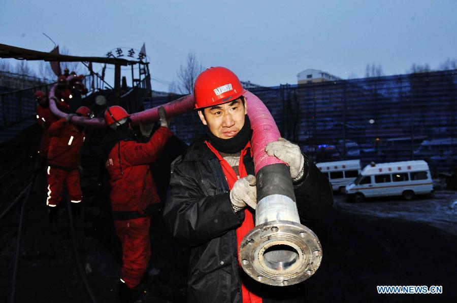 Rescuers carry a drain pipe to the head of the flooded mine in Qitaihe City, northeast China's Heilongjiang Province, Dec. 2, 2012. Rescuers on Sunday pulled two miners out alive while 14 others remain trapped after the Furuixiang Coal Mine in Qitaihe City was flooded on Saturday, according to local government sources. (Xinhua/Wang Jianwei) 