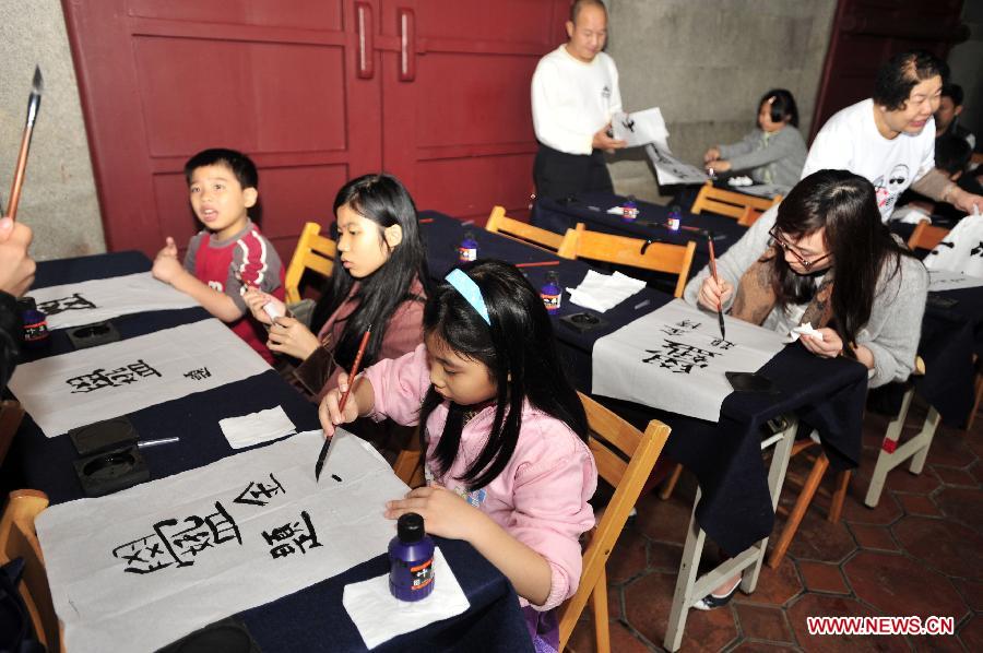 Several kids experience writing Chinese calligraphy during an activity at Taipei Confucius Temple in Taipei, southeast China's Taiwan Province, Dec. 2,2012. (Xinhua/Wu Ching-teng)