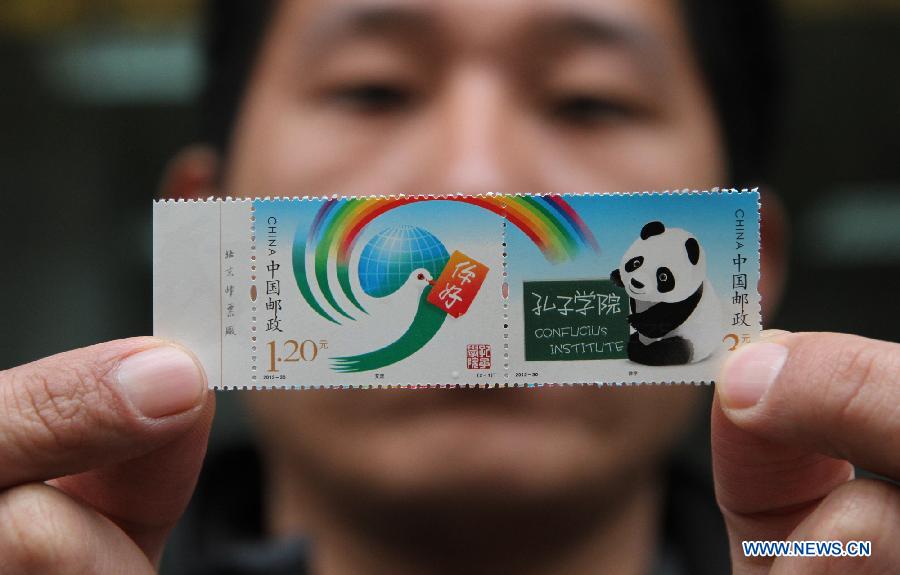 A philately lover shows the newly bought special stamps of Confucius Institute in Handan City, north China's Hebei Province, Dec. 1, 2012. China Post Group issued nationwide a set of special stamps of Confucius Institute themed "interaction"and "teaching" on Saturday. (Xinhua/Wang Jiuzhong) 