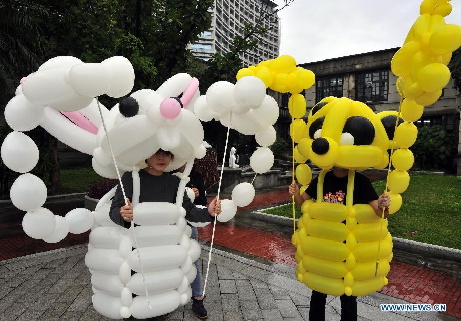 Two street artists demonstrate balloon costumes at a street entertainers' carnival held in the Songshan Cultural and Creative Park in Taipei, southeast China's Taiwan, Dec. 1, 2012. More than 40 street entertainment individuals and groups attended the two-day carnival which opened Saturday in Taipei. (Xinhua/Wu Ching-teng)