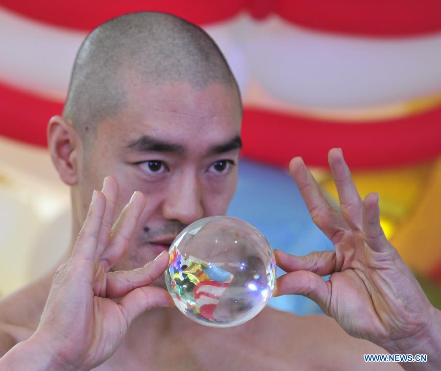 Street artist Hu Chi-chih performs crystal ball tricks at a street entertainers' carnival held in the Songshan Cultural and Creative Park in Taipei, southeast China's Taiwan, Dec. 1, 2012. More than 40 street entertainment individuals and groups attended the two-day carnival which opened Saturday in Taipei. (Xinhua/Wu Ching-teng)