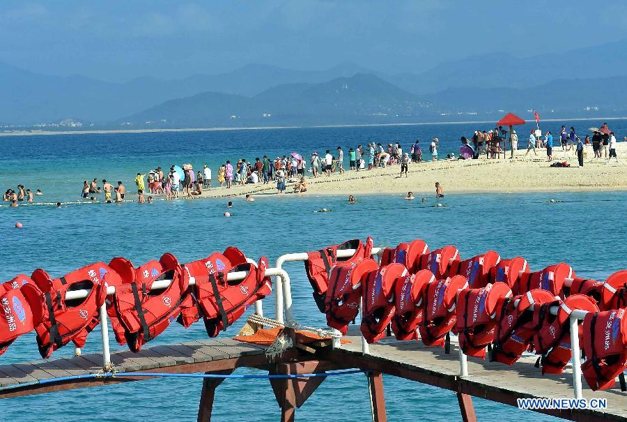 Tourists enjoy the seaside of Wuzhizhou Island, a scenic spot in Sanya, south China's Hainan Province, Dec. 1, 2012. Sanya has always been a winter tourism preferrence thanks to its tropical climate. (Xinhua/Wang Song) 