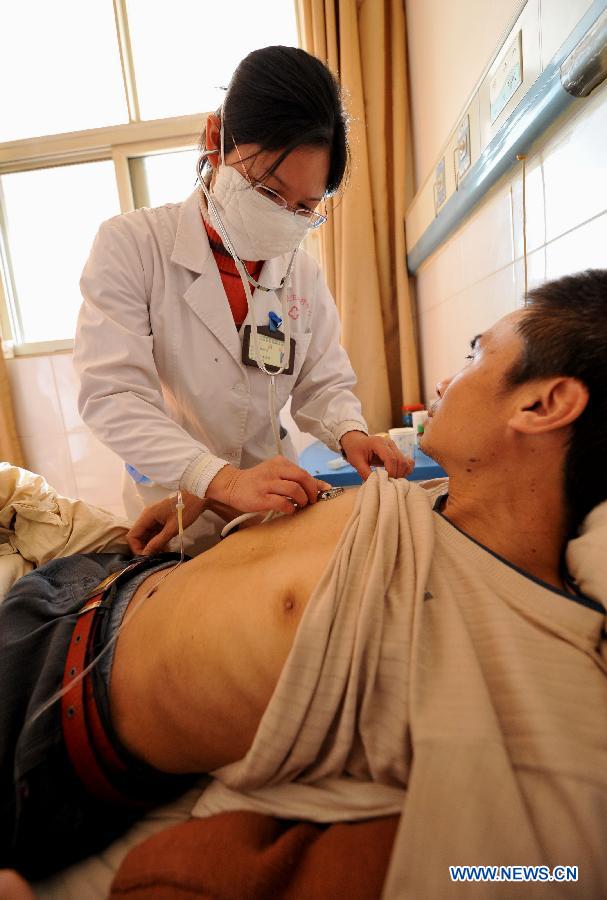 A doctor examines a patient's health condition at the Yunnan HIV/AIDS Care Center in Anning City, southwest China's Yunnan Province, Dec. 1, 2012.(Xinhua/Lin Yiguang)