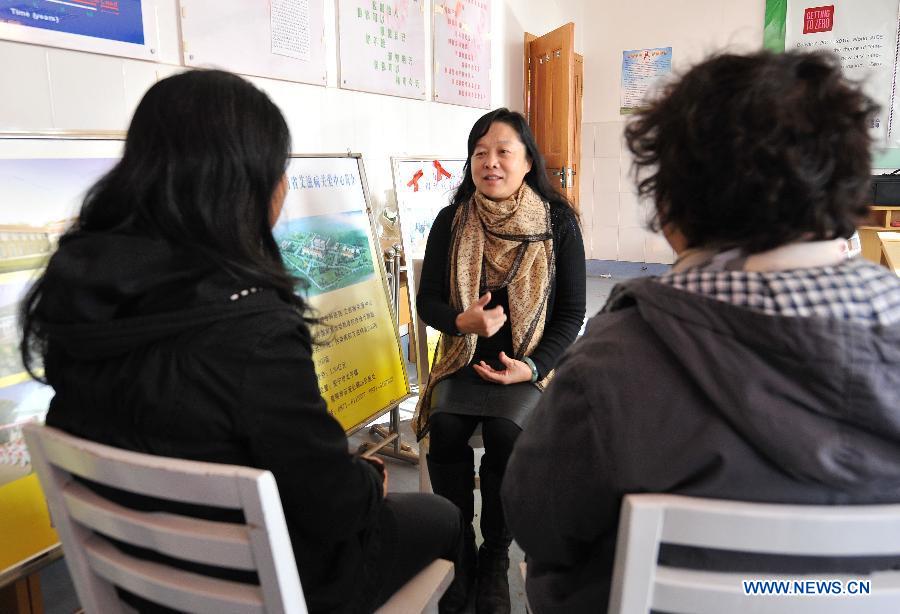 Chen Qingling (C), director of the care department, talks with family members of HIV/AIDS patients at the Yunnan HIV/AIDS Care Center in Anning City, southwest China's Yunnan Province, Dec. 1, 2012. (Xinhua/Lin Yiguang) 