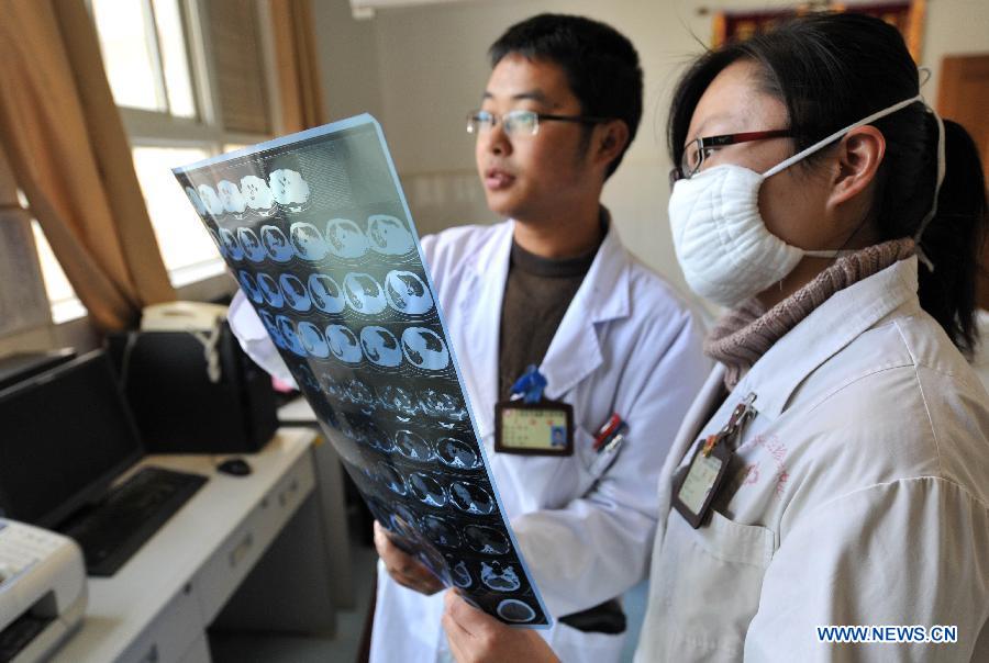 Doctors examine a CT scan result at the Yunnan HIV/AIDS Care Center in Anning City, southwest China's Yunnan Province, Dec. 1, 2012. (Xinhua/Lin Yiguang) 