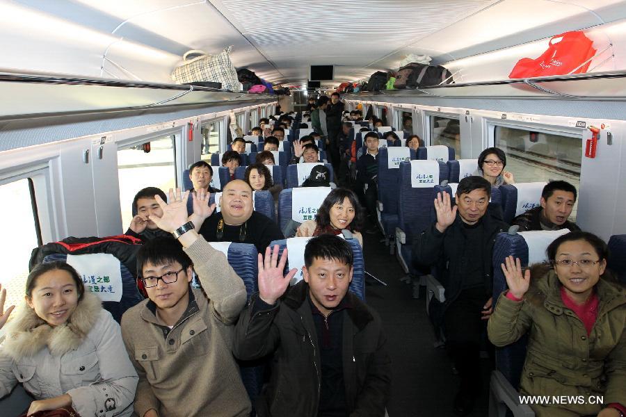 Passengers pose as they take the D501 high-speed train from Dalian North Railway Station to Harbin West Railway Station, Dec. 1, 2012. (Xinhua/Zhang Chunlei)
