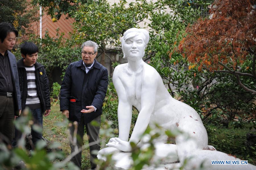 Renowned sculptor Zhou Guozhen (R) introduces one of his early works to visitors at his residence in Jingdezhen, east China's Jiangxi Province, Dec. 2, 2012. (Xinhua)