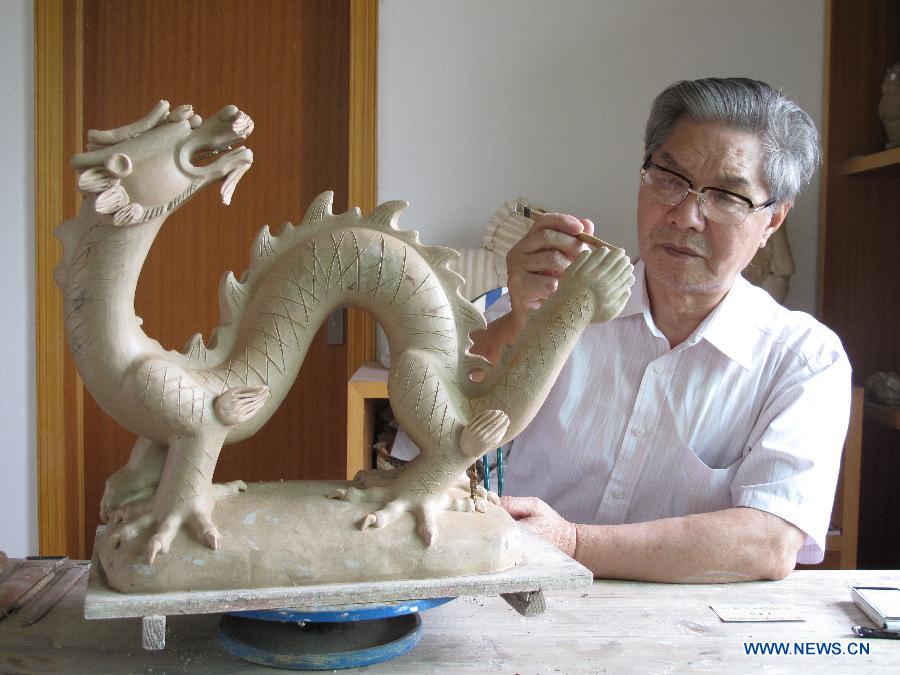 Renowned sculptor Zhou Guozhen works on a sculpture in Jingdezhen, east China's Jiangxi Province, Aug. 25, 2011. (Xinhua)