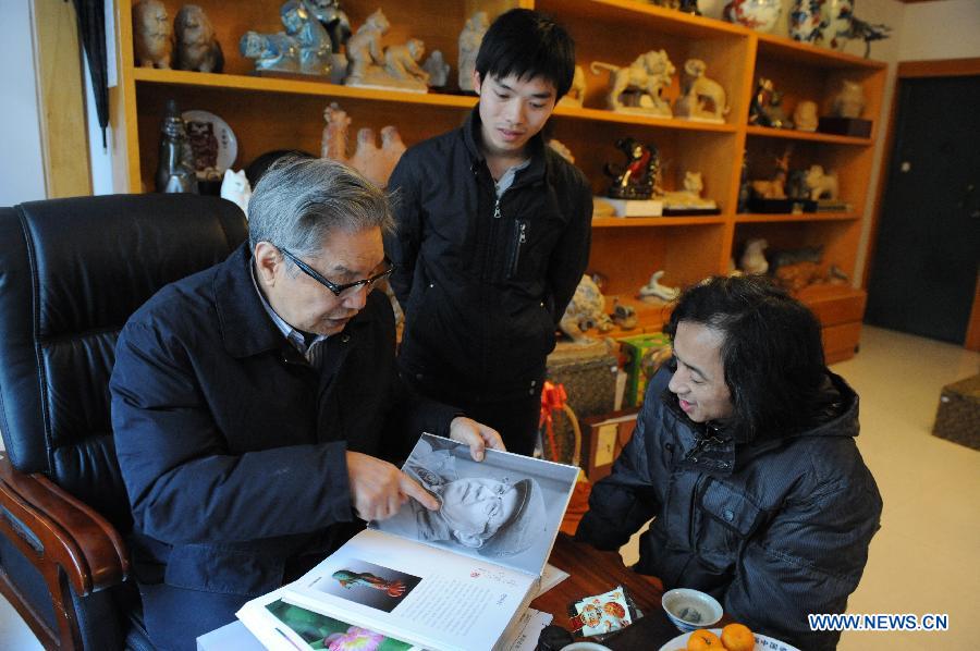 Renowned sculptor Zhou Guozhen (L) tells his art experiences during an interview in his workshop in Jingdezhen, east China's Jiangxi Province, Dec. 1, 2012. (Xinhua/Li Xinhua)