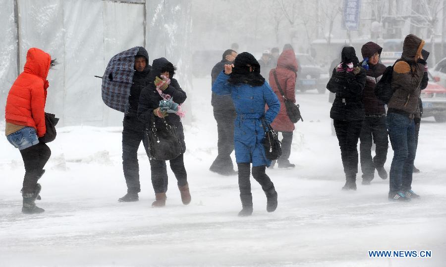 People walk hard amid snowstorm in Shenyang, capital of northeast China's Liaoning Province, Dec. 3, 2012. Liaoning Province issued a red alert for snowstorm on Monday morning, while closing an airport and expressways in the provincial capital of Shenyang. (Xinhua/Li Gang)