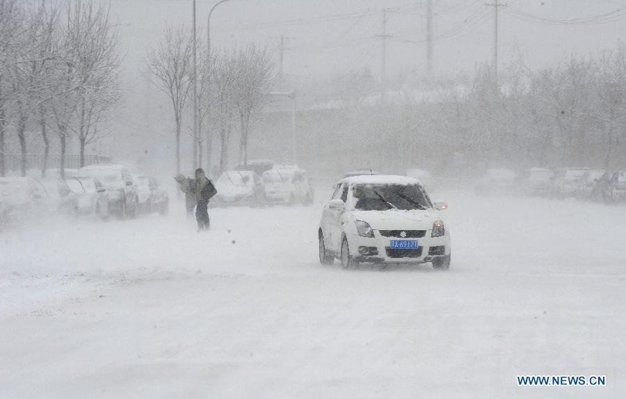 A car runs amid snowstorm in Shenyang, capital of northeast China's Liaoning Province, Dec. 3, 2012. Liaoning Province issued a red alert for snowstorm on Monday morning, while closing an airport and expressways in the provincial capital of Shenyang. (Xinhua/Li Gang) 