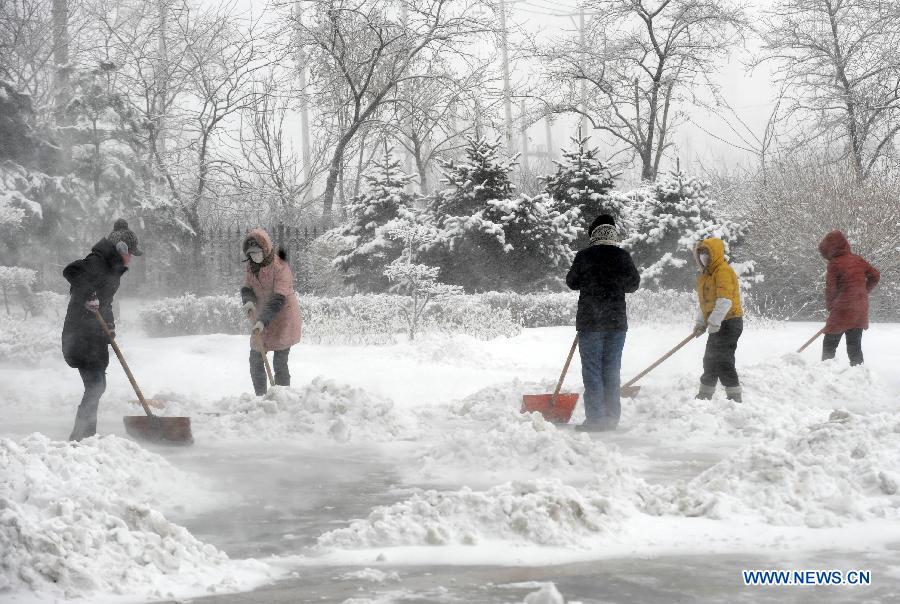 People clear off snow on the ground in Shenyang, capital of northeast China's Liaoning Province, Dec. 3, 2012. Liaoning Province issued a red alert for snowstorm on Monday morning, while closing an airport and expressways in the provincial capital of Shenyang. (Xinhua/Li Gang)
