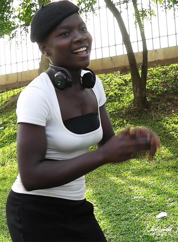  A girl in black and white wearing a set of headphone on her neck gives a big smile.(People's Daily Online/ Li Liang)