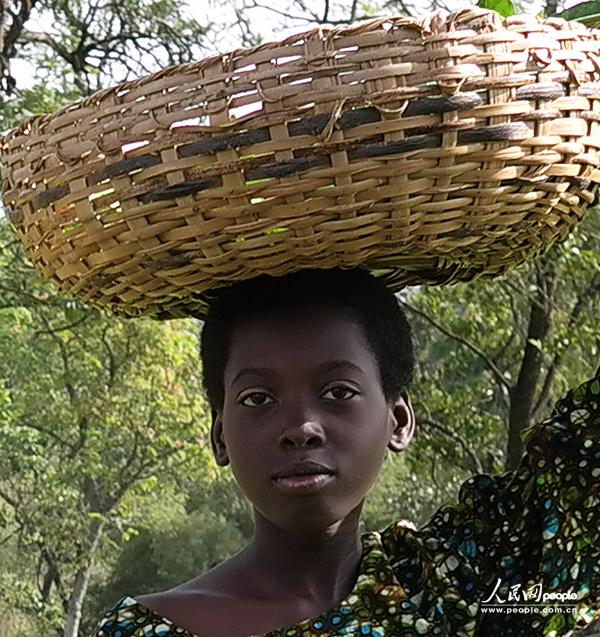 A child carries a basket on top of her head.(People's Daily Online/ Li Liang)