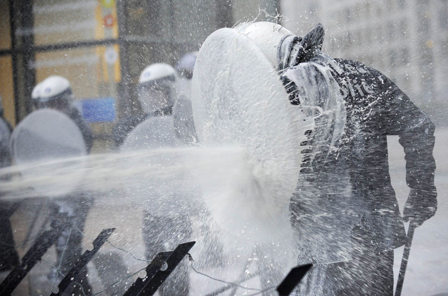 European milk producers dump milk on policemen walking in front of the European Parliament during a demonstration in Brussels November 26, 2012. (Xinhua/AFP Photo)