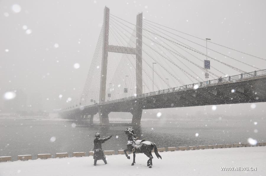Photo taken on Dec. 3, 2012 shows a view of the Linjiangmen Bridge amid snowstorm in Jilin, northeast China's Jilin Province. Snow fell in most parts of the northeast of China, and local area had a blizzard. Liaoning Province issued a continuous blizzard warning signal from early Monday morning, while issuing the first alert for the blizzard at Shenyang and other areas. (Xinhua) 