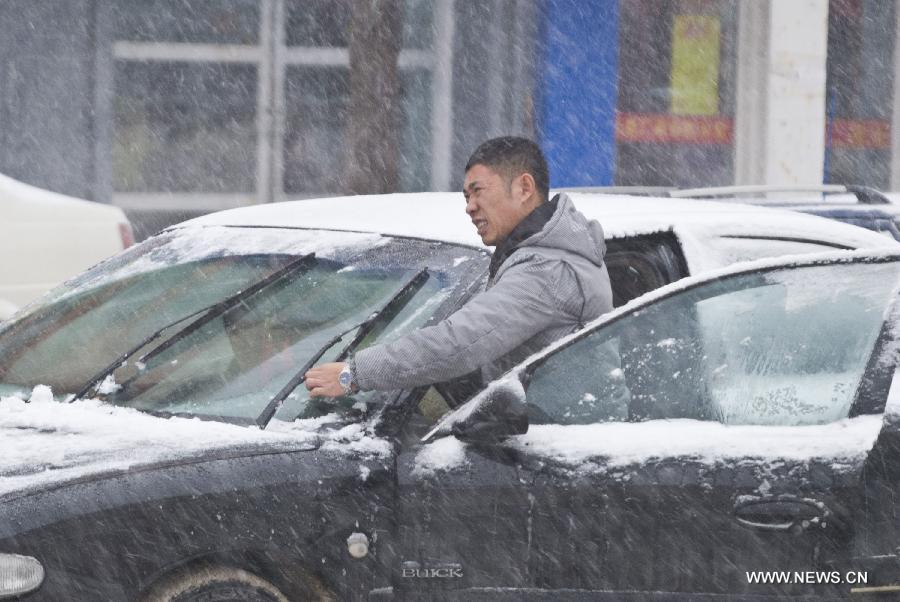 A man adjusts the wiper amid snowstorm at a street in Jilin, northeast China's Jilin Province, Dec. 3, 2012. Snow fell in most parts of the northeast of China, and local area had a blizzard. Liaoning Province issued a continuous blizzard warning signal from early Monday morning, while issuing the first alert for the blizzard at Shenyang and other areas. (Xinhua) 