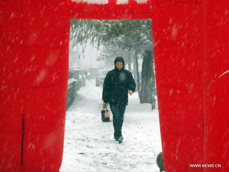 A man walks along a street amid snowstorm in Jilin, northeast China's Jilin Province, Dec. 3, 2012. Snow fell in most parts of the northeast of China, and local area had a blizzard. Liaoning Province issued a continuous blizzard warning signal from early Monday morning, while issuing the first alert for the blizzard at Shenyang and other areas. (Xinhua) 