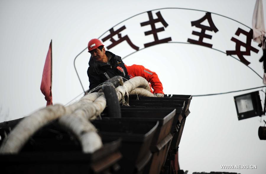A rescuer conveys water pipes to the Furuixiang Coal Mine in Qitaihe City, northeast China's Heilongjiang Province, Dec. 3, 2012. (Xinhua/Wang Jianwei)  