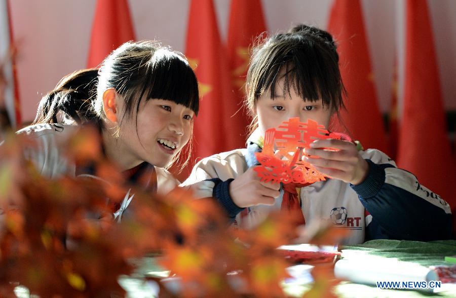Students practice paper cut at Hope Elementary School in Longwangmiao Township of Qinglong Man Autonomous County, north China's Hebei Province, Dec. 2, 2012. The school invited paper-cut artists to teach students the traditional Chinese paper cut art. (Xinhua/Yang Shiyao) 
