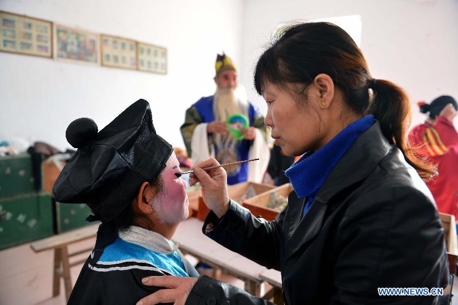 A performer from Xihuangcun Amateur Drama Group is put on make up in a dressing room in Xihuang Village of Zouping County, east China's Shandong Province, Nov. 24, 2012. (Xinhua/Zhu Zheng)