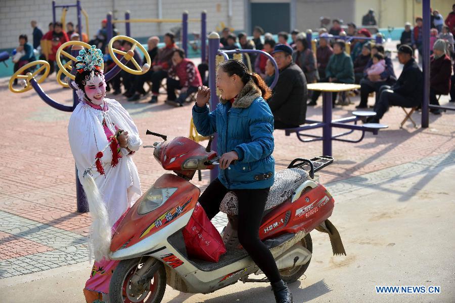 Miao Xueyan (L), performer from Xihuangcun Amateur Drama Group, talks with a villager during the break of a show in Xihuang Village of Zouping County, east China's Shandong Province, Nov. 24, 2012. (Xinhua/Zhu Zheng)