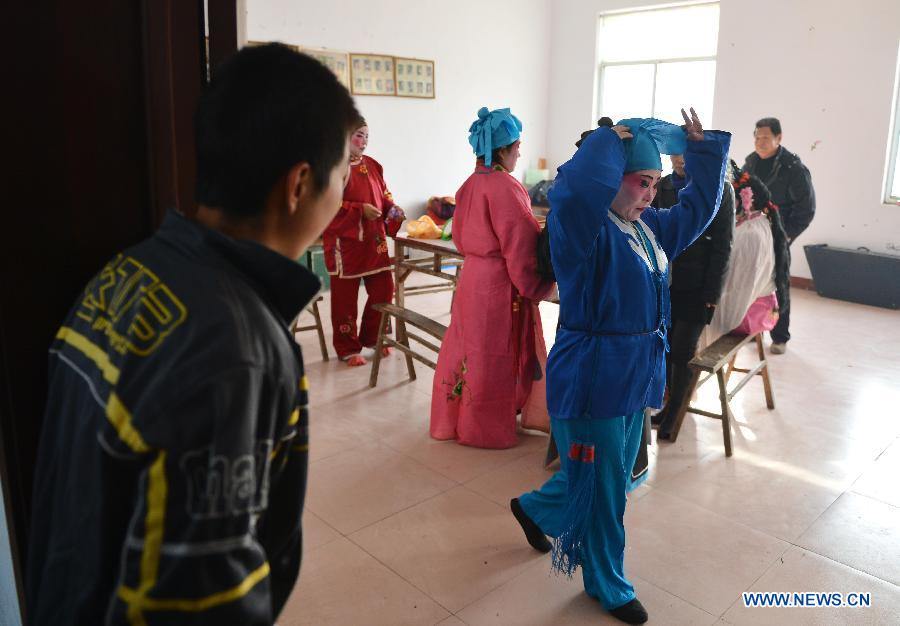 A villager watches performers from Xihuangcun Amateur Drama Group in a dressing room in Xihuang Village of Zouping County, east China's Shandong Province, Nov. 24, 2012. (Xinhua/Zhu Zheng)