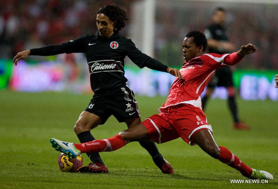 Player Wilson Tiago (R) of Toluca vies for the ball with Fernando Arce (L) of Tijuana during their Mexican Apertura tournament final football match, held at the Nemesio Diez stadium, in Toluca, State of Mexico, Mexico, on Dec. 2, 2012. (Xinhua/David de la Paz)